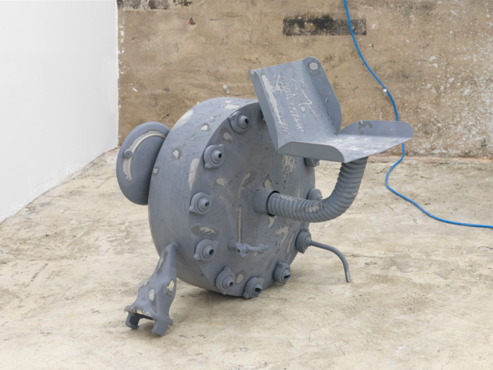 Grey industrial sculpture with seat by Dozie Kanu