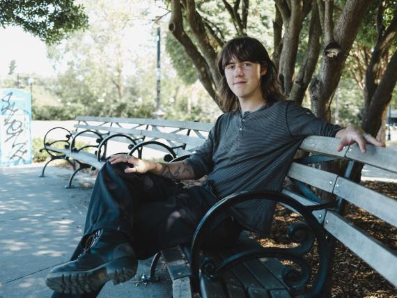 Burke's portrait sitting on a bench with trees in the background