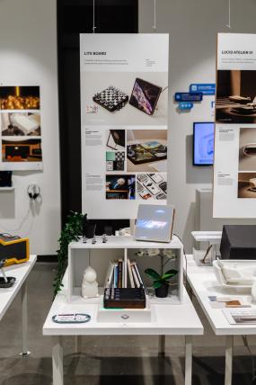 Exhibition view with hanging poster and display table.