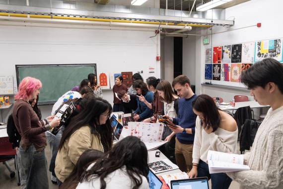 Students looking at publication projects created by design seniors