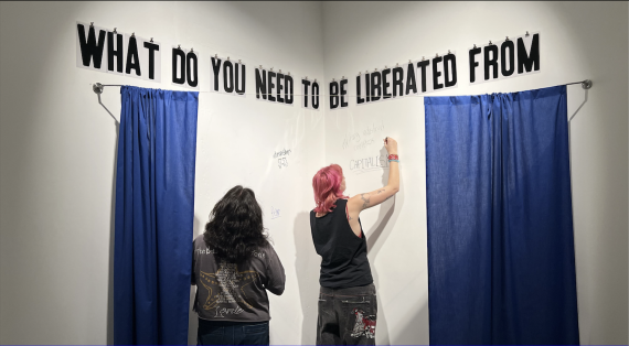 Visual Communication Design students installing vinyl letters in the gallery