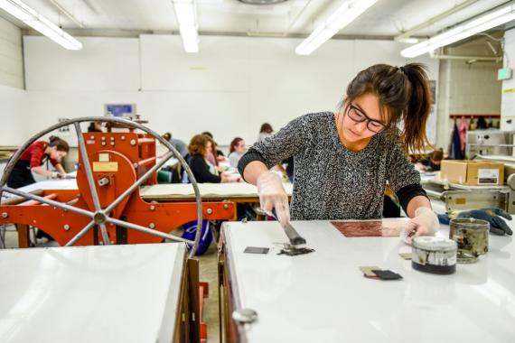 Student working on etching plate