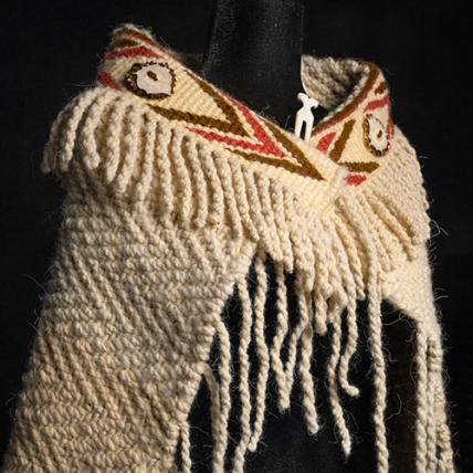 A woven shawl with a decorative band at the neck.