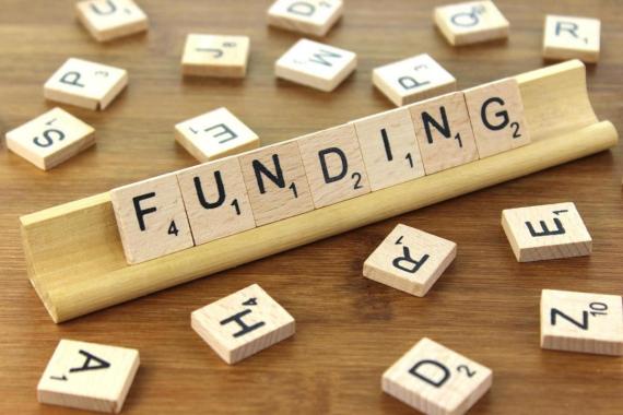 The word "Funding" spelled from Scrabble tiles