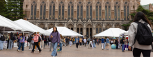 Students walk through Red Square near white tents.
