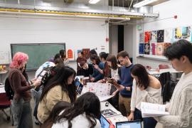 Students looking at publication projects created by design seniors