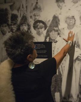 Close-up of exhibition with visitor touching a portrait