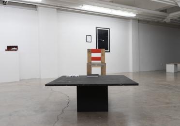 Exhibition view of a table and chair.
