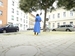 Person in blue dress standing alone in a city plaza