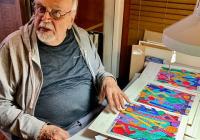 Richard Proctor showing one of his artwork portfolios in 2021