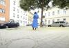 Person in blue dress standing alone in a city plaza