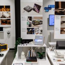 Exhibition view with hanging poster and display table.