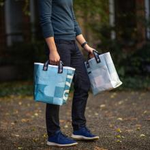 Close-up of model holding two tote bags with different patterns