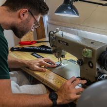 Design student sewing one of the tote bags