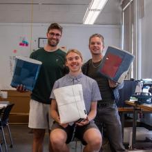 Group photo of student designers holding tote bags