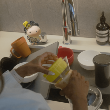 Person interacting with characters from Todo project while washing the dishes
