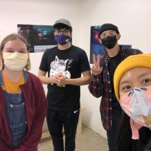 Four students wearing masks in a gallery setting