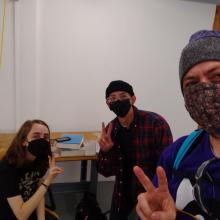 Three students wearing face masks in a studio setting