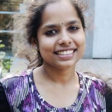 Portrait of Lalitha Bandaru in a purple scoop-necked geometric print shirt.