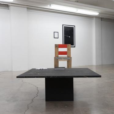 Exhibition view of a table and chair.