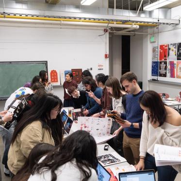 Students looking at publication projects created by design seniors