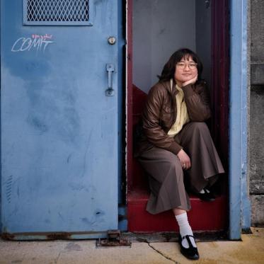 Close-up of Alum Vivian Cho sitting on the University Bridge